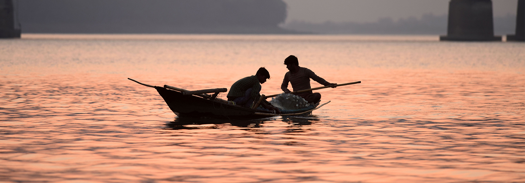 Fishermen paddle their boats back after fishing in the Brahmaputra River on the outskirts of Guwahati. (BIJU BORO/AFP/Getty Images)