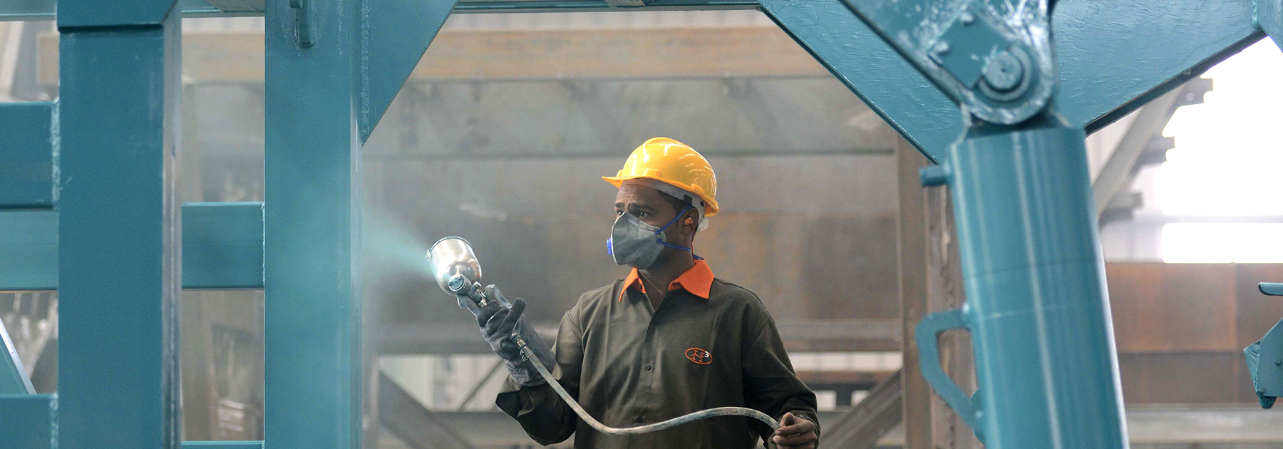 A worker spray paints a steel frame at a heavy fabrication manufacturing factory in Vasna Buzarg village. (SAM PANTHAKY/AFP/Getty Images)