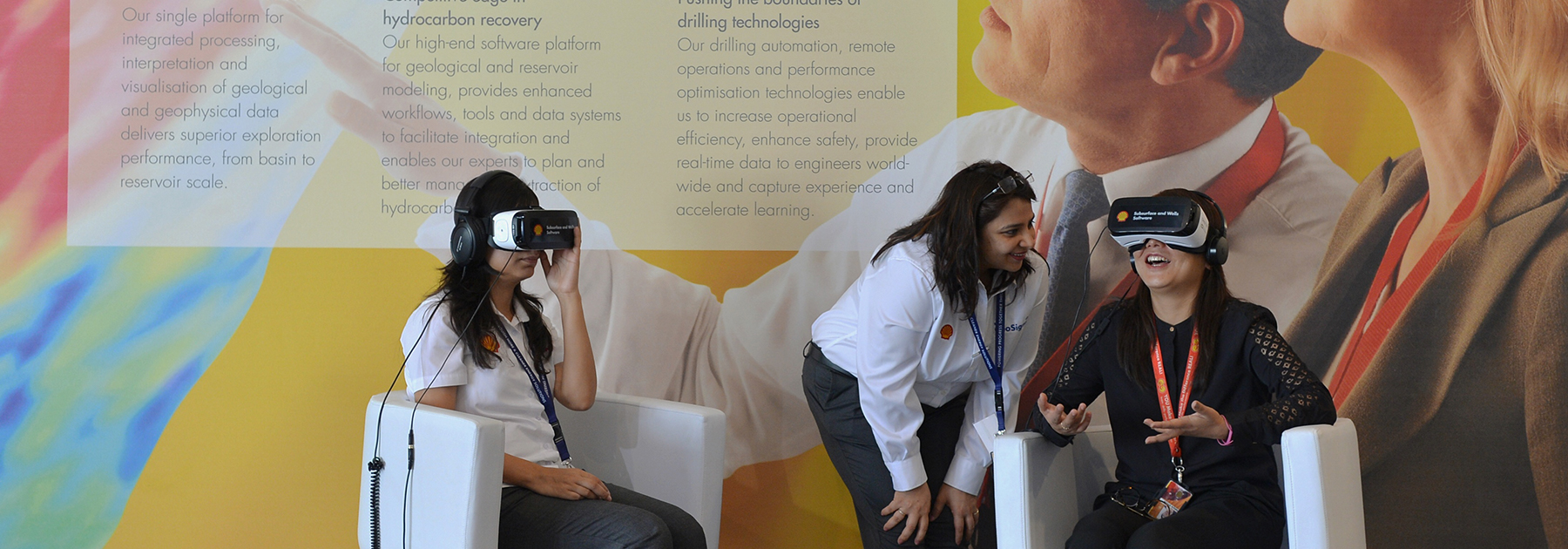 An employee of Shell company (C) helps visitors take a tour of Shell refineries using Virtual Reality goggles in Bangalore. (MANJUNATH KIRAN/AFP/Getty Images)